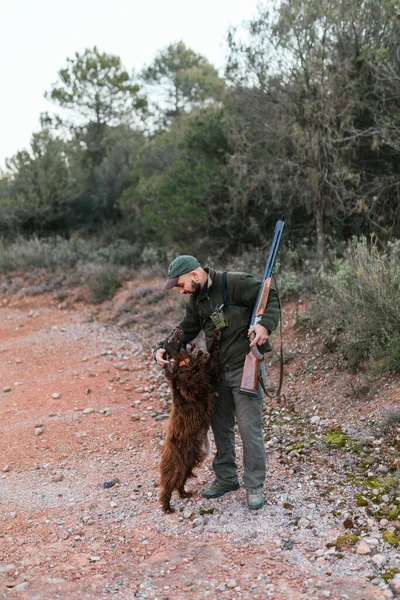 田舎の後ろ足で犬を撫でるハンター — ストック写真