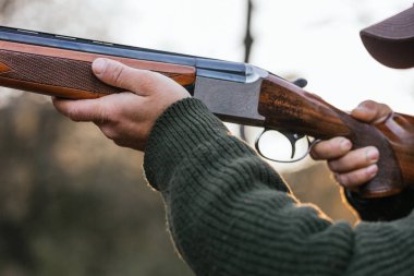 Doğada avlanırken tüfeği hedef alan adam.