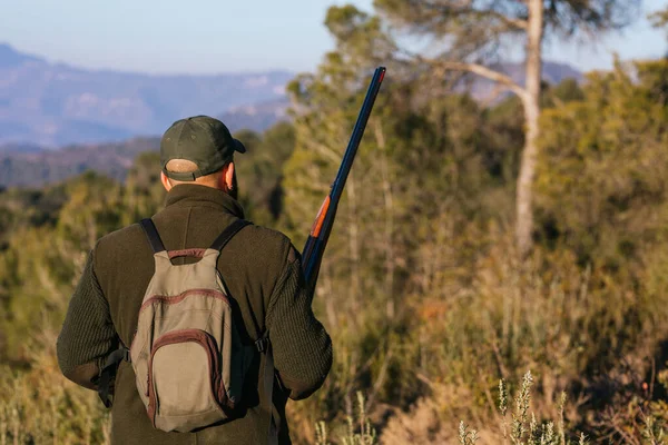 Jäger auf dem Rücken mit Gewehr in der Natur unterwegs — Stockfoto