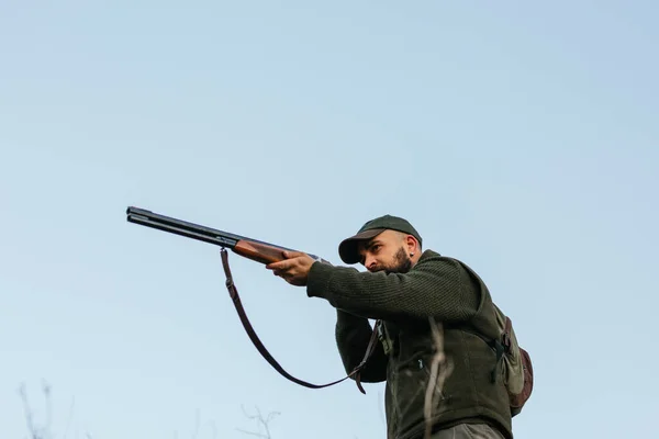 Hunter aiming with his gun with sky in background — Stock Photo, Image