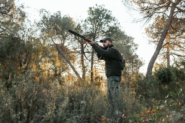 Junger Jäger zielt mit der Schrotflinte in die Natur — Stockfoto