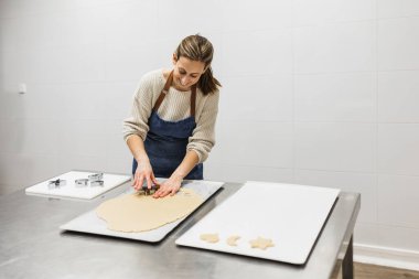 Pasta dükkanında farklı şekillerde kurabiyeler yapan mutlu aşçı..