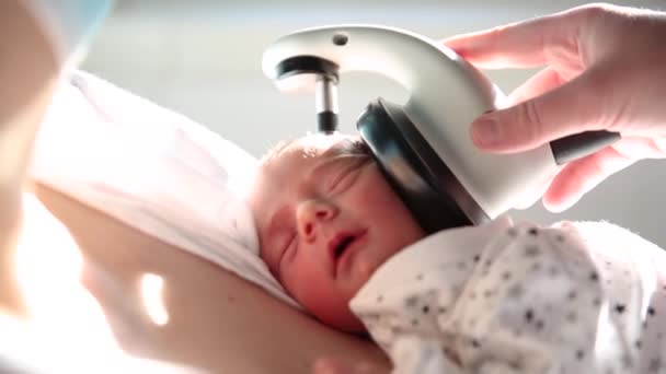 Doctor doing a hearing screening test on a newborn baby at the hospital. — Vídeo de Stock