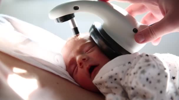 Zbliżenie widok noworodka poddającego się badaniu przesiewowemu słuchu w szpitalu. — Wideo stockowe