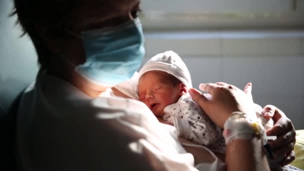Γυναίκα φορώντας μάσκα προσώπου ενώ κρατά το νεογέννητο μωρό της. — Αρχείο Βίντεο