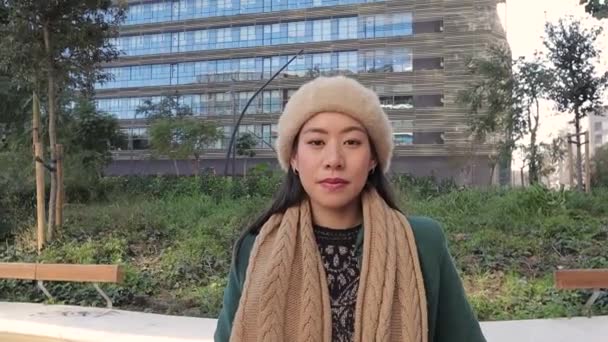 Confident Asian businesswoman looking at camera and smiling while standing on the street in financial district. — Stockvideo