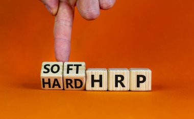 HRP, insan kaynakları planlama sembolü. İşadamı ahşap küpleri değiştirip sert HRP 'yi yumuşak HRP' ye çeviriyor. Güzel turuncu arka plan. İş, HRP, insan kaynakları planlaması. Boşluğu kopyala.