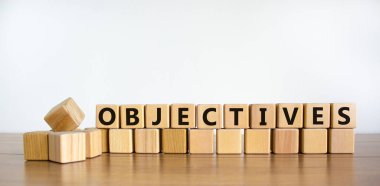 Hedeflerin sembolü. Tahta küplerdeki nesneler kelimesi. Güzel ahşap masa, beyaz arka plan. İş ve hedef kavramı. Boşluğu kopyala.