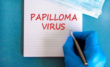 Papilloma virüsü sembolü. Beyaz notta Papilloma virüsü, güzel mavi arkaplan, doktor eli mavi eldiven ve metal kalem var. Tıbbi maske. Tıbbi ve papilloma virüsü kavramı.