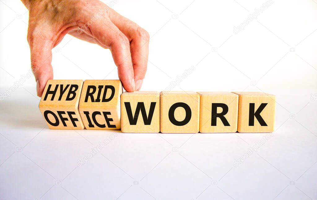 Hybrid or office work symbol. Businessman turns cubes and changes words 'office work' to 'hybrid work'. Beautiful white background. Business, hybrid or office working concept, copy space.