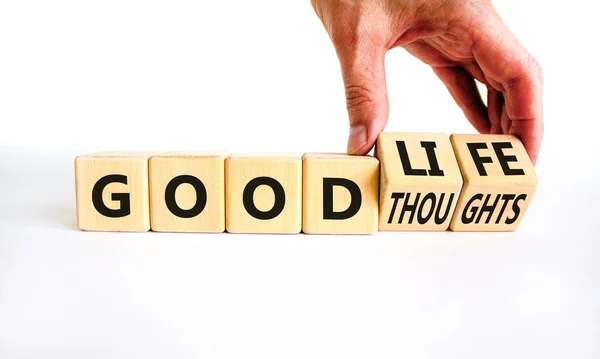 Good thoughts and life symbol. Businessman turns wooden cubes and changes words \'good thoughts\' to \'good life\'. Beautiful white background, copy space. Business and good thoughts and life concept.