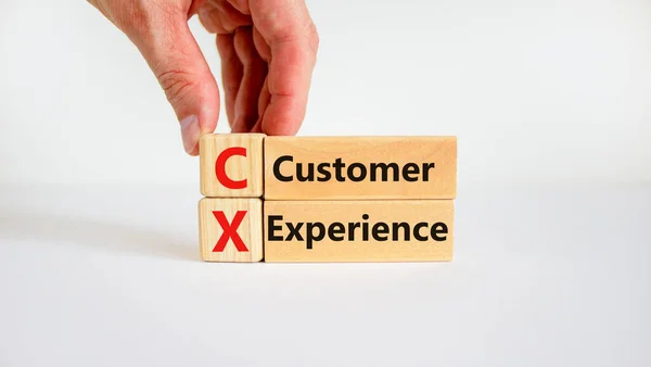 CX customer experience symbol. Concept words \'CX customer experience\' on wooden blocks on white table, white background, copy space. Businessman hand. Business and CX customer experience concept.