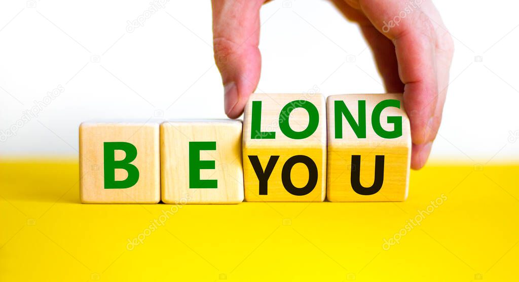 Be you, belong symbol. Businessman hand turns cubes and changes words 'be you' to 'belong'. Beautiful white background. Business, belonging and be you, belong concept. Copy space.
