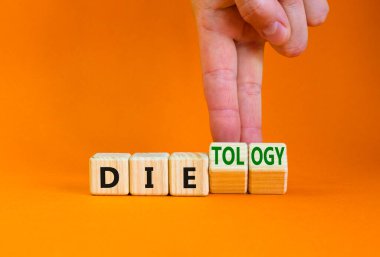 Dietoloji bunun yerine ölüm sembolü. Doktor ahşap küpleri değiştiriyor ve ölüm kelimesini dietolojiye çeviriyor. Güzel turuncu masa, turuncu arka plan. Sağlıklı yaşam tarzı, diyetoloji onun yerine konsept ölüyor. Boşluğu kopyala.