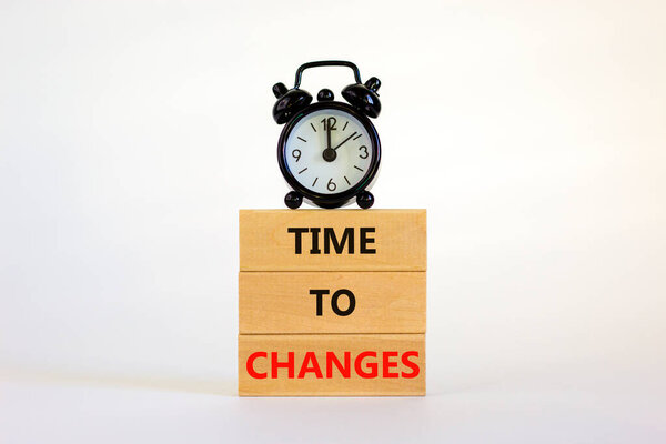 Time to changes symbol. Concept words 'Time to changes' on wooden blocks. Black alarm clock. Beautiful white background. Business and time to changes concept. Copy space.