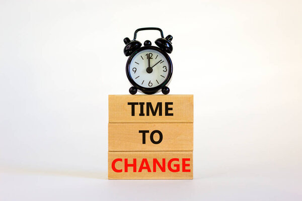 Time to change symbol. Concept words 'Time to change' on wooden blocks. Black alarm clock. Beautiful white background. Business and time to change concept. Copy space.
