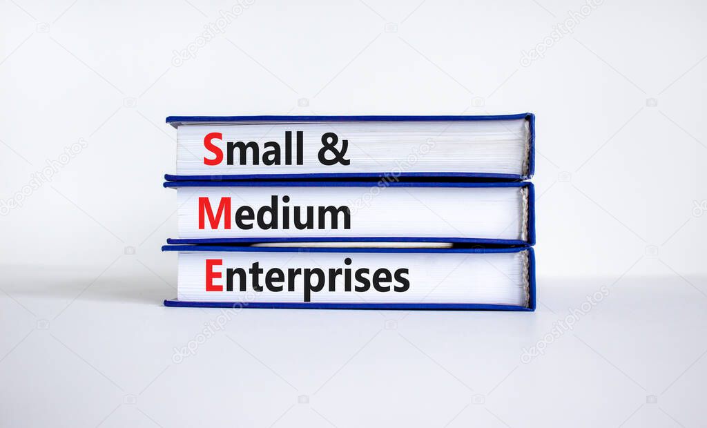 SME small and medium enterprises symbol. Words SME small and medium enterprises on books on a beautiful white table, white background. Business, SME small and medium enterprises concept. Copy space.