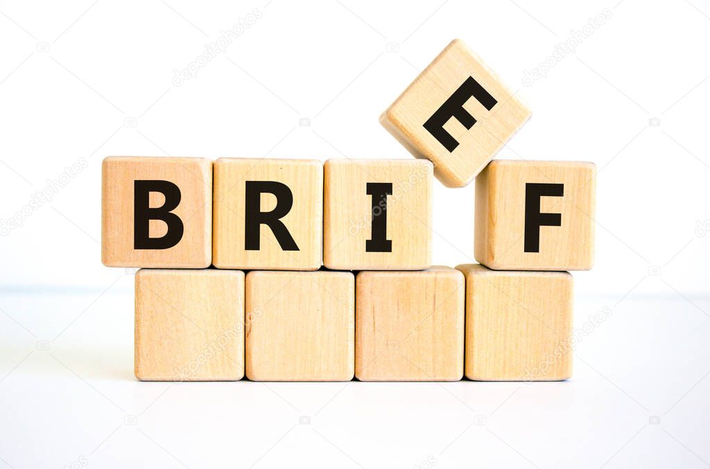 Brief symbol. The concept word 'brief' on wooden cubes on a beautiful white table, white background. Business and brief concept. Copy space.