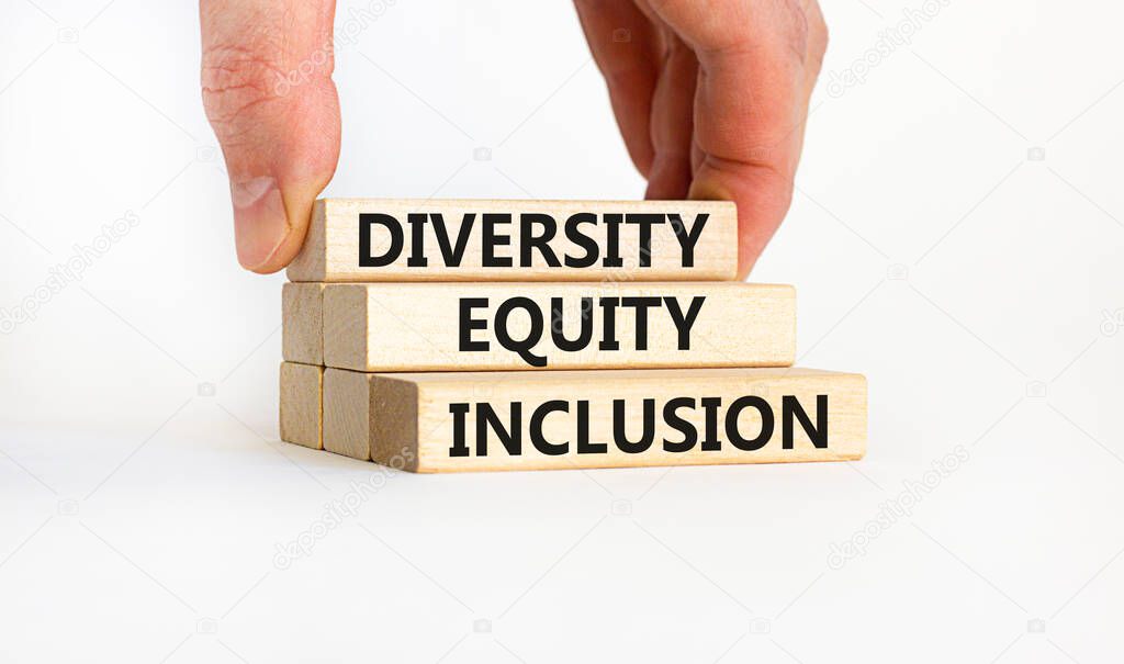 Diversity equity inclusion symbol. Concept words 'Diversity equity inclusion' on wooden blocks on beautiful white background. Businessman hand. Diversity, business, inclusion and equity concept.