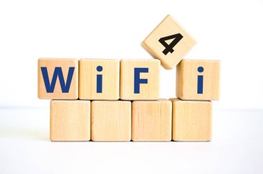 Wi-Fi 4 sembolü. Kablosuz ağ 4 'ün tahta küplere konsepti. Güzel beyaz masa, beyaz arka plan, kopyalama alanı. İş, teknoloji ve WiFi 4 veya WiFi4 kavramı.