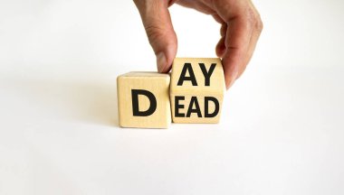 Ölü sembolü günü. İş adamı bir tahta küpü dönüştürür ve 'Ölü' kelimesini 'Gün' e çevirir. Güzel beyaz masa, beyaz arka plan, kopyalama alanı. Ölü kavram günü.