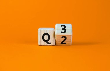 İkinci çeyrekten üçüncü çeyreğe kadar. Tahta bir küp yaptı ve 'Q2' yi 'Q3' olarak değiştirdi. Güzel turuncu masa, turuncu arka plan. İş dünyası, mutlu 3. çeyrek Q3 konsepti, kopyalama alanı.