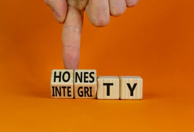 Dürüstlük ve dürüstlük sembolü. İş adamı ahşap küplere dönüşür ve dürüstlük kelimesini değiştirir. Güzel turuncu arkaplan, kopyalama alanı. İş ve dürüstlük ve dürüstlük kavramı.