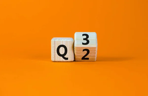 İkinci çeyrekten üçüncü çeyreğe kadar. Tahta bir küp yaptı ve 'Q2' yi 'Q3' olarak değiştirdi. Güzel turuncu masa, turuncu arka plan. İş dünyası, mutlu 3. çeyrek Q3 konsepti, kopyalama alanı.