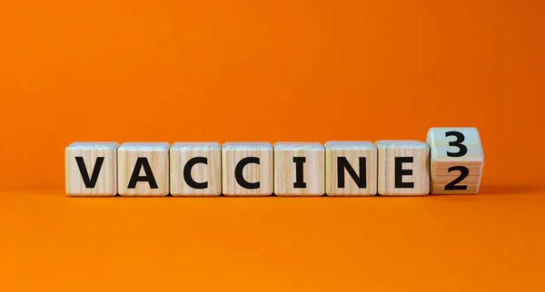 Covid 19助推器疫苗打针符号 转动了一个木制立方体 疫苗2 疫苗3 漂亮的橙色背景 复制空间 Covid 19型助推器疫苗接种概念 — 图库照片