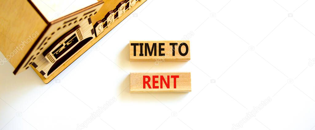 Time to rent house symbol. Concept words 'Time to rent' on wooden blocks near miniature house. Beautiful white background, copy space. Business and time to rent house concept.