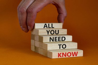 Tüm bilmen gereken sembol. Bilmen gereken tek şey, turuncu arka planda tahta bloklar, kopyalama alanı. İşadamı eli. İş, tek bilmen gereken konsept..