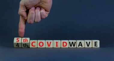 Covid-19 Corona virüsünün beşinci dalgasının sembolü. Doktorlar küpleri çevirir ve kelimeleri değiştirirler. 4. Covid dalgası 5. Covid dalgası. Güzel gri arkaplan. Covid-19 konseptinin beşinci dalgası. Boşluğu kopyala.