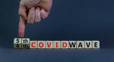 Covid-19 Corona virüsünün beşinci dalgasının sembolü. Doktorlar küpleri çevirir ve kelimeleri değiştirirler. 4. Covid dalgası 5. Covid dalgası. Güzel gri arkaplan. Covid-19 konseptinin beşinci dalgası. Boşluğu kopyala.