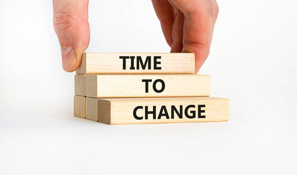 Time to change symbol. Concept words 'Time to change' on wooden blocks. Businessman hand. Beautiful white background. Business and time to change concept. Copy space.