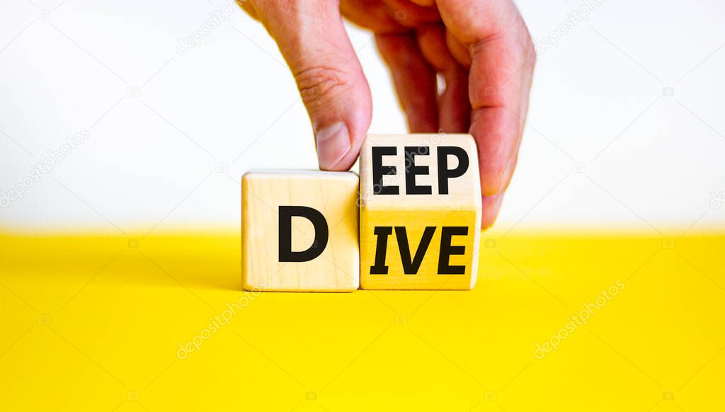 Deep dive symbol. Businessman turns a wooden cube with words 'Deep dive'. Beautiful yellow table, white background. Deep dive and business concept. Copy space.