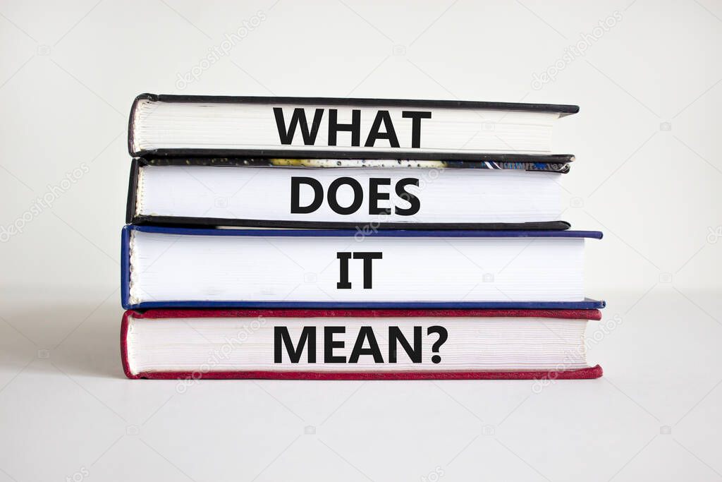 What does it mean symbol. Concept words 'what does it mean' on books on a beautiful white background. Businessman hand. Business and what does it mean concept. Copy space.