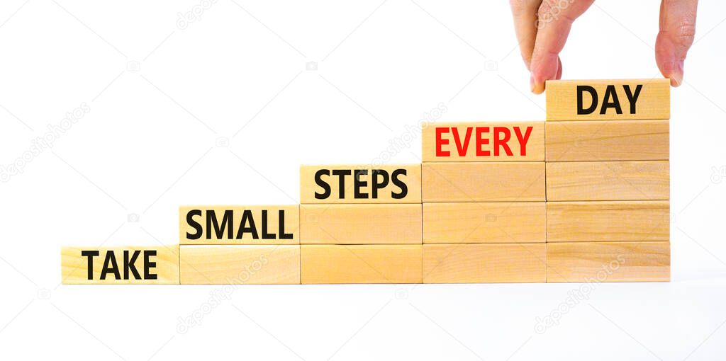 Take small steps every day symbol. Wooden blocks with words Take small steps every day. Beautiful white background, copy space. Businessman hand. Business, step every day concept.