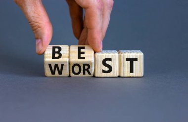 En iyi veya en kötü sembol. İş adamı ahşap küplere dönüşür ve en iyi sözcüğü en kötüye çevirir. Güzel gri masa, gri arkaplan, kopyalama alanı. İş ve en iyi veya en kötü kavram.