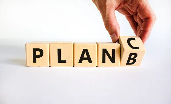 stock image Plan B or C symbol. Businessman turns a wooden cube and changes words Plan B to Plan C. Beautiful white table, white background, copy space. Business and Plan B or C planning concept.