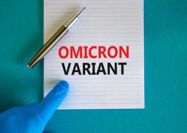 Yeni covid-19 omikron varyant türü sembolü. Beyaz notlu mavi eldiven verin. Omicron değişkeni kavramsal kelimeler. Metalik kalem. Tıbbi ve COVID-19 omikron varyant türü konsepti. Boşluğu kopyala.
