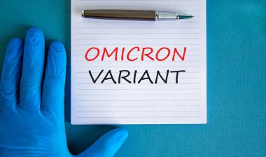 Yeni covid-19 omikron varyant türü sembolü. Beyaz notlu mavi eldiven verin. Omicron değişkeni kavramsal kelimeler. Metalik kalem. Tıbbi ve COVID-19 omikron varyant türü konsepti. Boşluğu kopyala.
