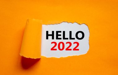 2022 Merhaba yeni yıl sembolü. Sözcükler Merhaba 2022 yırtık turuncu kağıdın arkasında beliriyor. Güzel turuncu arka plan. İş dünyası, merhaba 2022 Yeni yıl konsepti, kopyalama alanı.