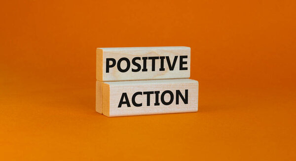 Time to positive action symbol. Wooden blocks with concept words 'Positive action'. Beautiful orange background. Business and positive action concept. Copy space.