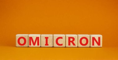 Covid-19 yeni omicron gerilim sembolü. Omicron 'un tahta küplerdeki konsepti. Güzel turuncu arka plan. Uzayı kopyala Tıbbi ve COVID-19 yeni omikron türü değişken virüs konsepti.