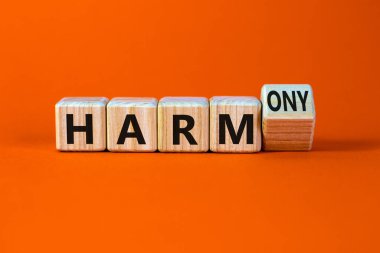 Zarardan armoniye. Tahta bir küp yaptı ve kelime zararını ahenge çevirdi. Güzel turuncu masa, turuncu arka plan. İş ve zarar ya da uyum kavramı. Boşluğu kopyala.