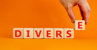 Çeşitlilik ve çeşitlilik sembolü. Tahta küplerde çeşitlilik kavramı. Güzel turuncu masa, turuncu arka plan, fotokopi alanı. İşadamı eli. İş çeşitliliği ve çeşitli kavramlar.