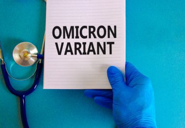 Yeni covid-19 omikron varyant türü sembolü. Beyaz notlu mavi eldiven verin. Omicron değişkeni kavramsal kelimeler. Steteskop. Tıbbi ve COVID-19 omikron varyant türü konsepti. Boşluğu kopyala.
