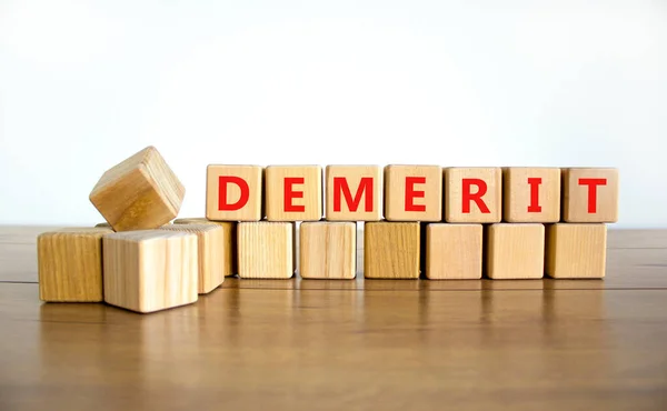 stock image Demerit symbol. The concept word Demerit on wooden cubes. Beautiful wooden table, white background, copy space. Business and demerit concept.