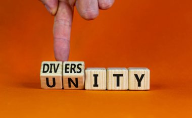 Çeşitlilik ve birlik sembolü. İş adamı ahşap küplere dönüşür ve Birlik kelimesini çeşitliliğe çevirir. Güzel turuncu masa, turuncu arka plan, fotokopi alanı. İş, çeşitlilik ve birlik kavramı.