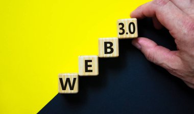 Web 3.0 sembolü. İçinde konsept sözcükler olan tahta küpler, web 3.0. Güzel sarı ve siyah arkaplan, kopyalama alanı. İşadamı eli. İş, teknoloji web3 ve WEB 3.0 konsepti.